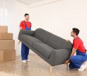 Professional Movers Carrying Sofa In New House