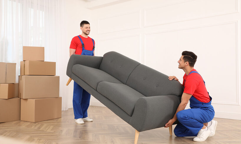 Professional Movers Carrying Sofa In New House
